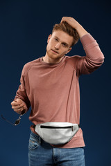 Fashionable young man on color background