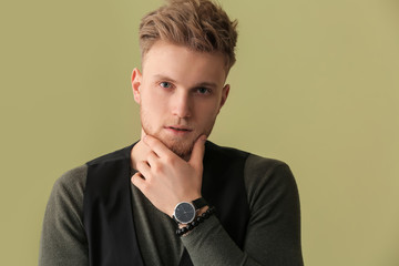 Fashionable young man on color background