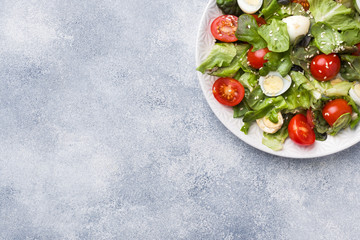 Fresh salad with tomatoes and quail eggs and lettuce. Copy space