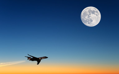 modern airplane business jet flying on beautiful sunset sky with full moon landscape background at dusk dawn time scenic aerial up silhouette plane view corporate air travel concept copy space banner - Powered by Adobe