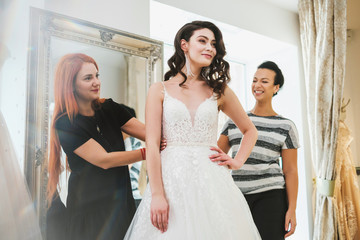 Beautifu bride choosing wedding dress in a wedding salon