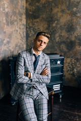 Naklejka premium A man in a blue suit is sitting on a chair