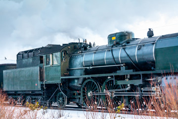 Fototapeta na wymiar Old retro steam train at winter morning in Finland