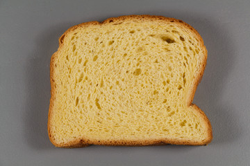 One slice of brioche on gray background