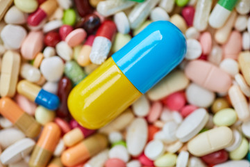 Große Pille auf einem Haufen Medikamente
