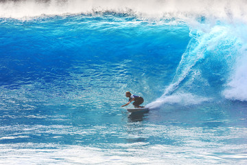 Silhouette surfer riding the big blue surf waves on the island Madeira, Portugal, a popular surfing tourist destination