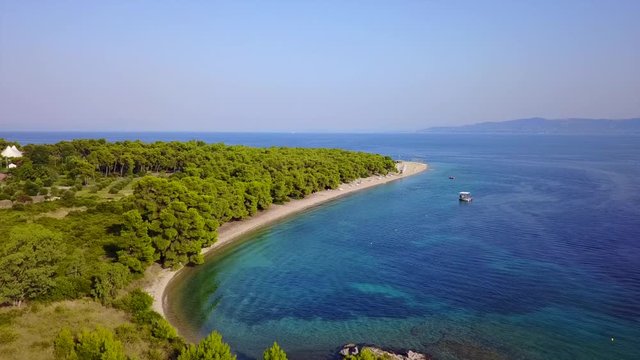 Aerial bird's eye view video taken by drone of exotic seascape and sandy beach with turquoise clear waters and pine trees, Gregolimano, North Evoia island, Greece