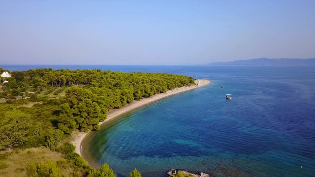 Aerial bird's eye view video taken by drone of exotic seascape and sandy beach with turquoise clear waters and pine trees, Gregolimano, North Evoia island, Greece