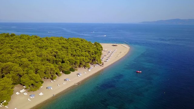 Aerial bird's eye view video taken by drone of exotic seascape and sandy beach with turquoise clear waters and pine trees, Gregolimano, North Evoia island, Greece