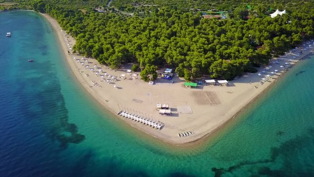 Aerial bird's eye view video taken by drone of exotic seascape and sandy beach with turquoise clear waters and pine trees, Gregolimano, North Evoia island, Greece