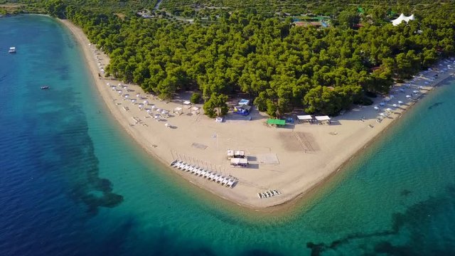 Aerial bird's eye view video taken by drone of exotic seascape and sandy beach with turquoise clear waters and pine trees, Gregolimano, North Evoia island, Greece