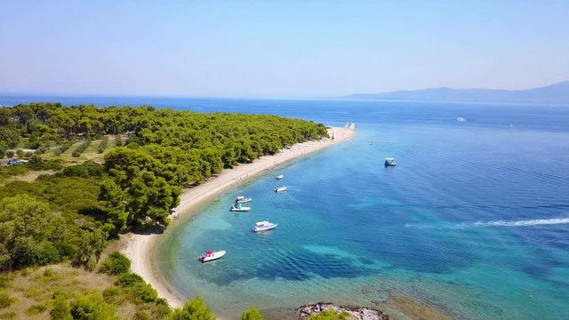 Aerial bird's eye view video taken by drone of exotic seascape and sandy beach with turquoise clear waters and pine trees, Gregolimano, North Evoia island, Greece