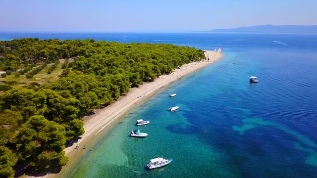 Aerial bird's eye view video taken by drone of exotic seascape and sandy beach with turquoise clear waters and pine trees, Gregolimano, North Evoia island, Greece