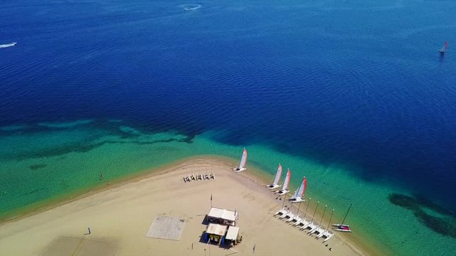 Aerial bird's eye view video taken by drone of exotic seascape and sandy beach with turquoise clear waters and pine trees, Gregolimano, North Evoia island, Greece