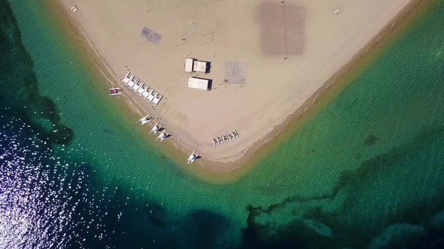 Aerial bird's eye view video taken by drone of exotic seascape and sandy beach with turquoise clear waters and pine trees, Gregolimano, North Evoia island, Greece