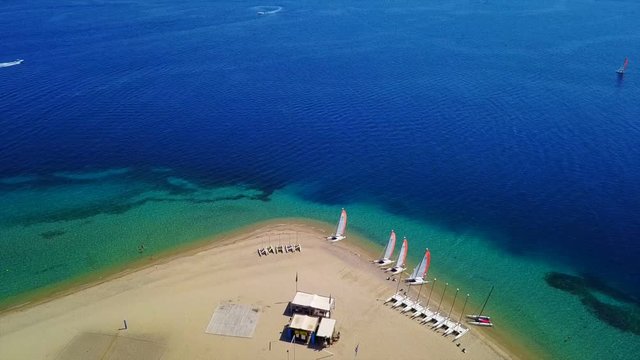 Aerial bird's eye view video taken by drone of exotic seascape and sandy beach with turquoise clear waters and pine trees, Gregolimano, North Evoia island, Greece