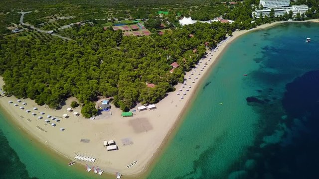 Aerial bird's eye view video taken by drone of exotic seascape and sandy beach with turquoise clear waters and pine trees, Gregolimano, North Evoia island, Greece