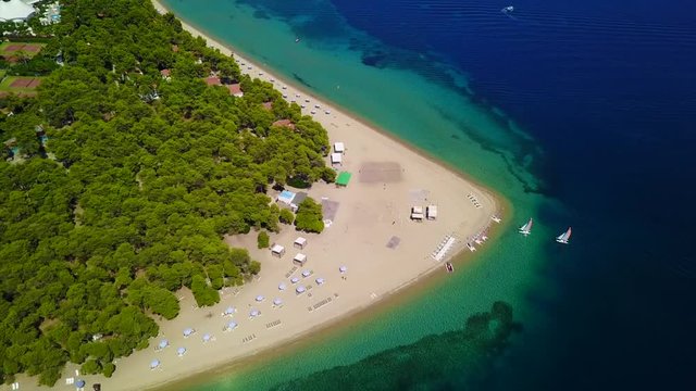 Aerial bird's eye view video taken by drone of exotic seascape and sandy beach with turquoise clear waters and pine trees, Gregolimano, North Evoia island, Greece