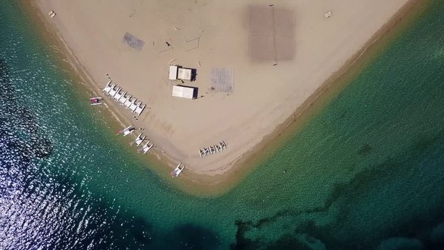 Aerial bird's eye view video taken by drone of exotic seascape and sandy beach with turquoise clear waters and pine trees, Gregolimano, North Evoia island, Greece