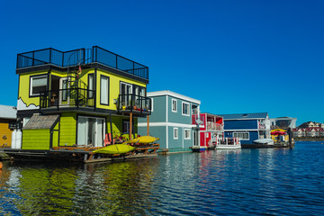 Floating Home Village colorful Houseboats Water Taxi Fisherman's Wharf Reflection Inner Harbor, Victoria British Columbia Canada Pacific Northwest. Area has floating homes, piers, restaurants.