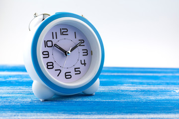 The alarm clock is on a painted blue Board.