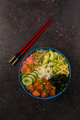Hawaiian salmon poke bowl with seaweed, avocado, sesame seeds.