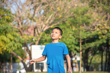 Portrait of a boy Asia laughing and smiling happily Background blurry trees in park.