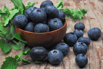Blueberries in wooden bowls on old wooden background. Rustic style