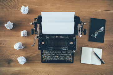 Vintage writer's desk with typewriter with crumpled papers