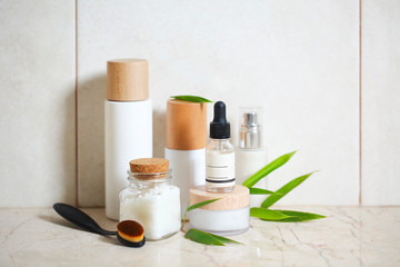 Obraz na płótnie Canvas Face cream, serum, lotion, moisturizer and sea salt among bamboo leaves