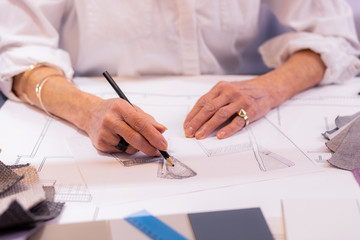 Mug shot of aging female boss working on project drawing