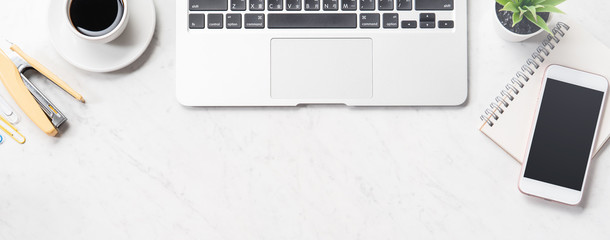 Stylized clean marble office working desk with smartphone, laptop, glasses and coffee cup,...