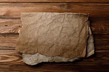 brown old parchment sheet lying on wooden background