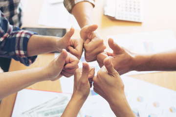 close up hand of business  people bump hands thumb up finishing up meeting showing unity , business teamwork concept
