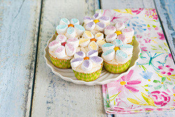 Cupcakes decorated with butter cream and marshmallow flowers