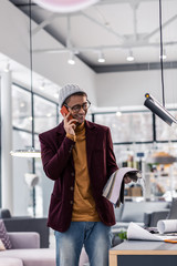 30-years-old handsome procurement manager discussing textile delivery via phone