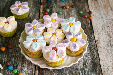 Cupcakes decorated with butter cream and marshmallow flowers