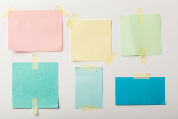 colorful blank papers with sticky tape on white background