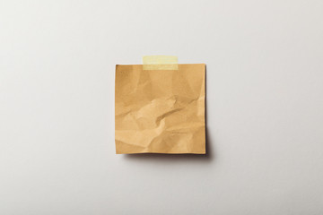 brown blank paper with sticky tape on white background