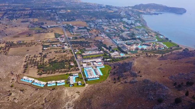 Aerial birds eye view video taken by drone of crowded beach of Kolympia with popular resorts and pools, Rodos island, Greece