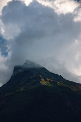 Fototapeta na wymiar Peaks of Dombai mountains in summer rain clouds
