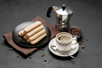 Italian Savoiardi ladyfingers Biscuits and cup of coffee on concrete backgound