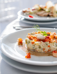 Olivier salad, traditional salad, restaurant dish, salad with shrimp and quail eggs and red caviar, new year's salad