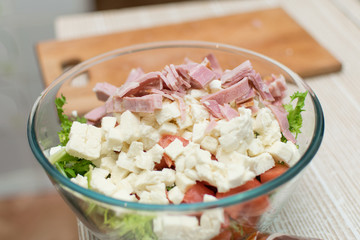 Cooking salad from fresh vegetables and cheese.