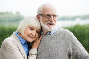 happy stylish senior woman leaning on husband shoulder
