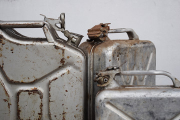 Three gray cans with petrol or diesel, metal barrel