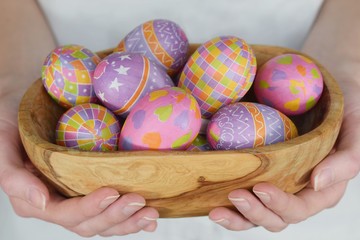 Easter eggs in the bowl in woman hands