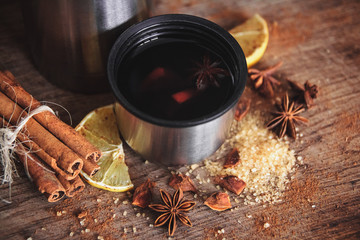 Obraz na płótnie Canvas Freshly homemade mulled wine in a bowl with fragrant species, citrus fruits, lemon on a wooden rusric board