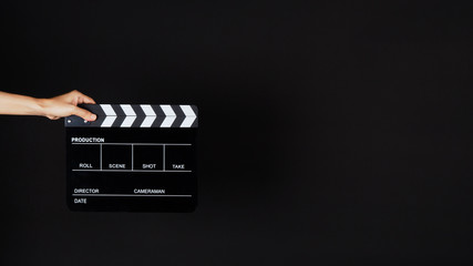 Hand's holding Clapperboard or movie slate use in video production ,film, cinema industry on black background.