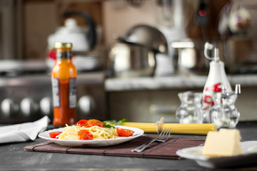 Spaghetti pasta in tomato sauce with cheese and parsley. Italian spaghetti pasta over dark stone background.